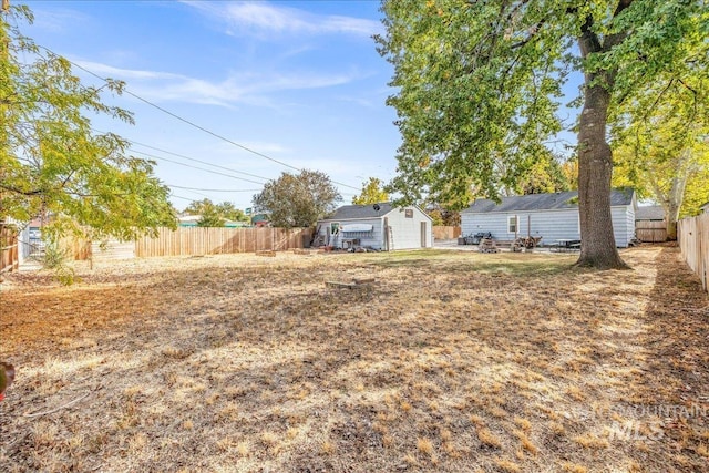 fenced backyard featuring an outbuilding