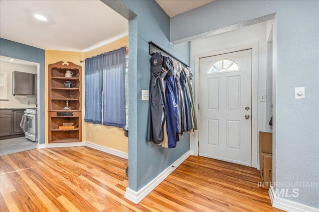 entrance foyer featuring light wood-type flooring, baseboards, and a textured wall