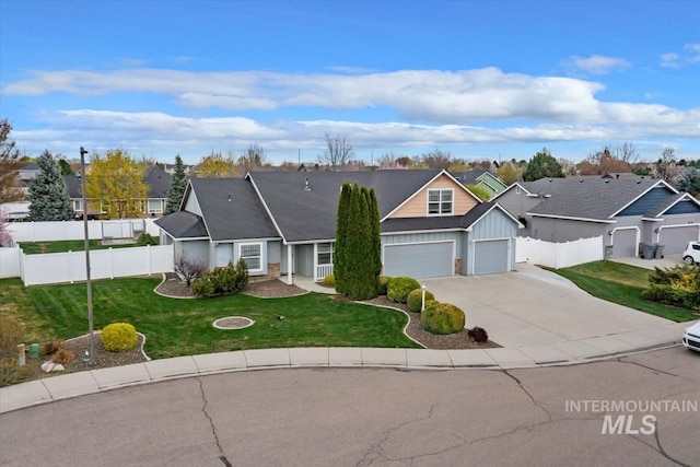 view of front of house with board and batten siding, fence, concrete driveway, a front lawn, and a residential view
