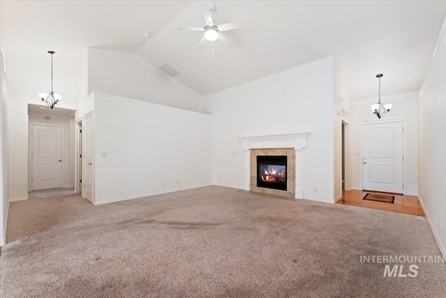 unfurnished living room featuring baseboards, a fireplace, carpet floors, ceiling fan with notable chandelier, and high vaulted ceiling