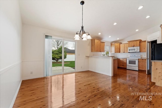 kitchen featuring a chandelier, white appliances, a peninsula, wainscoting, and light wood finished floors