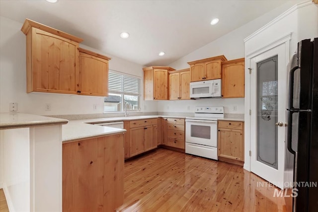 kitchen with white appliances, a peninsula, light countertops, lofted ceiling, and light wood finished floors