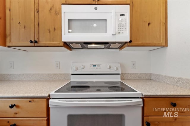 kitchen featuring white appliances, light brown cabinets, and light countertops