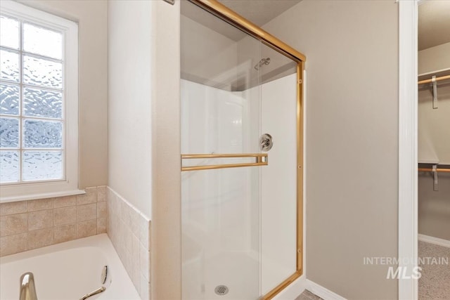 full bath with a shower stall, plenty of natural light, and a spacious closet