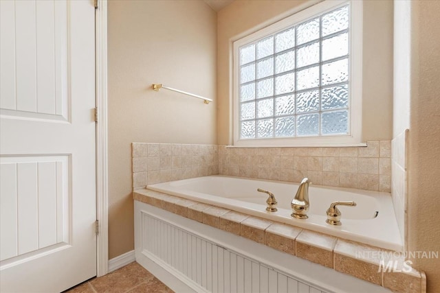 bathroom with tile patterned flooring and a garden tub