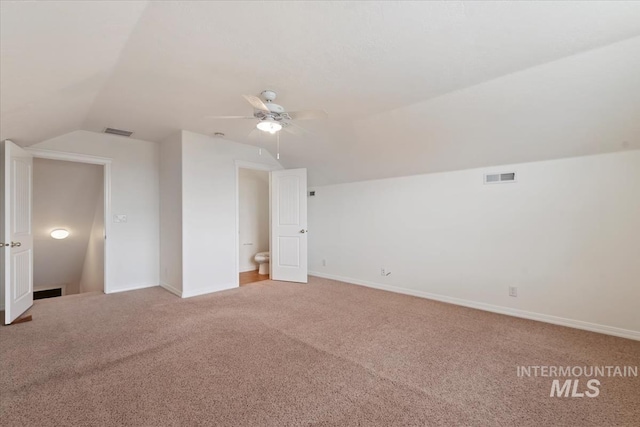 bonus room with visible vents, vaulted ceiling, and light carpet