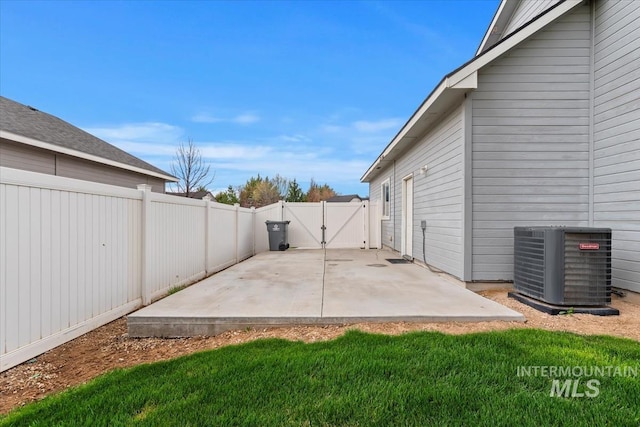 view of patio featuring central air condition unit, a fenced backyard, and a gate