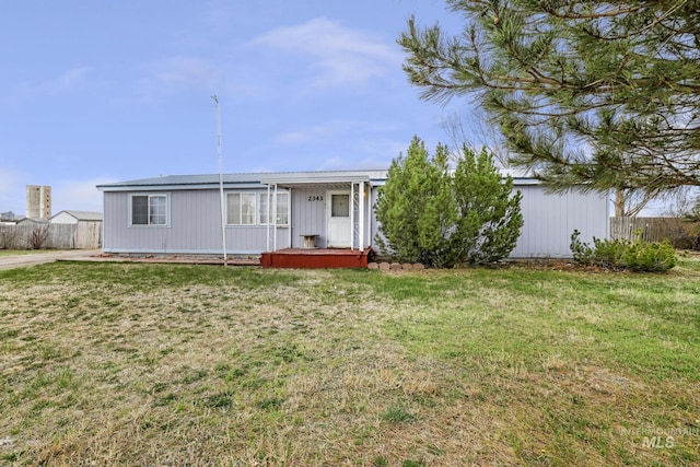 rear view of property with a yard and fence