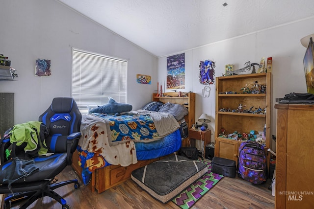 bedroom featuring vaulted ceiling and wood finished floors