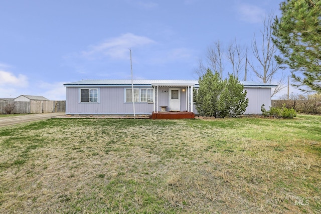 view of front of house with fence, a front yard, and metal roof