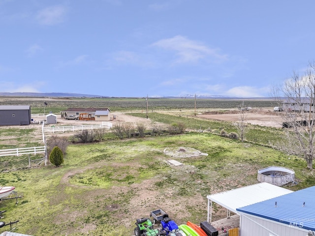 view of yard with fence and a rural view