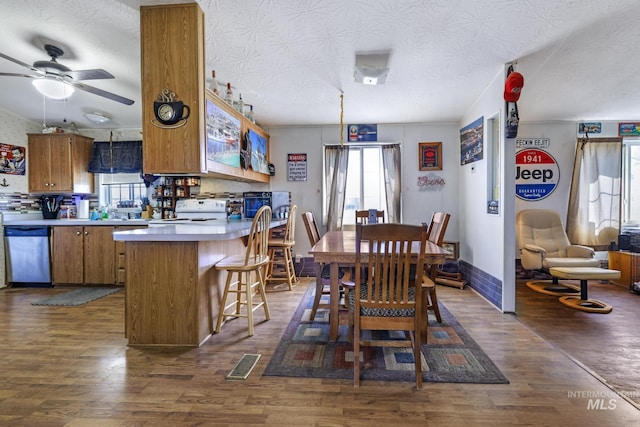 dining space with dark wood finished floors, visible vents, and a ceiling fan