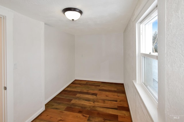 interior space with baseboards and wood finished floors