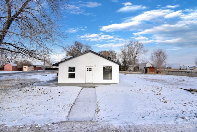 snow covered structure featuring an outbuilding