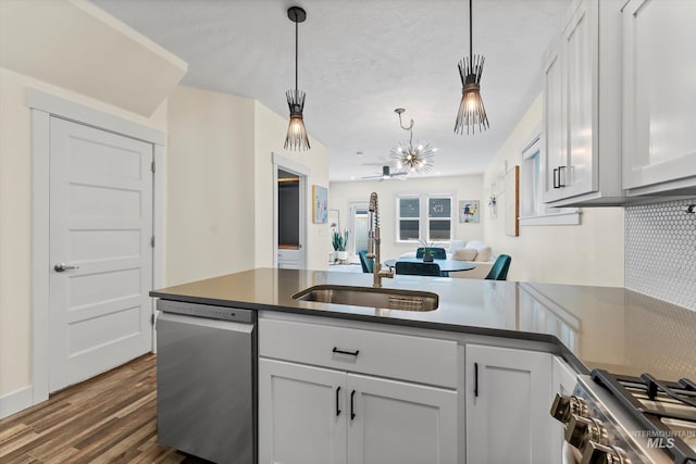 918 N 31st St, Boise, ID 83702 - kitchen with stainless steel appliances, dark wood-style flooring, dark countertops, a peninsula, and hanging light fixtures