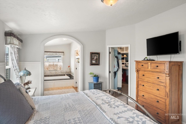 bedroom with ensuite bathroom, a walk in closet, and a closet