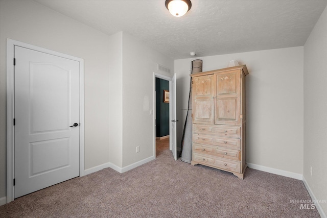 unfurnished bedroom featuring carpet floors and a textured ceiling