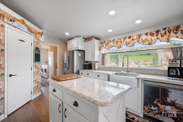 kitchen featuring white cabinets, dishwasher, stainless steel fridge, separate washer and dryer, and dark wood-type flooring