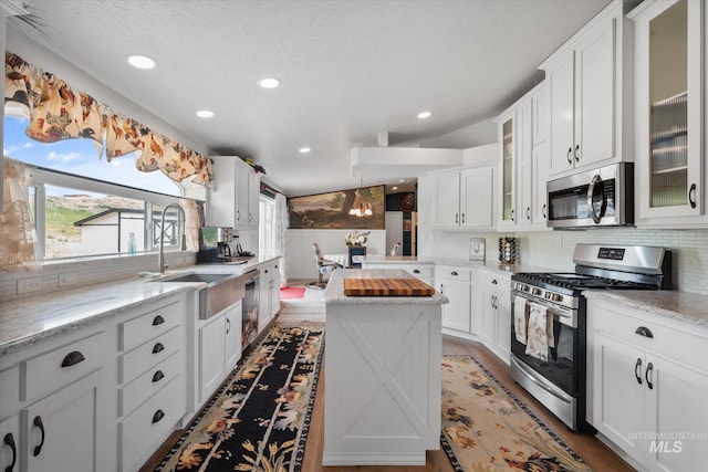 kitchen featuring dark hardwood / wood-style flooring, tasteful backsplash, light stone counters, and stainless steel appliances