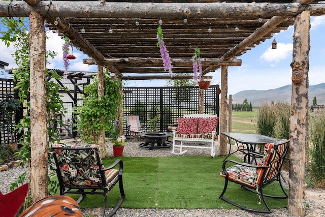 view of yard with a pergola, a mountain view, and an outdoor fire pit