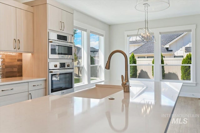 13958 Levendi Ct, Caldwell, ID 83607 - kitchen featuring light countertops, a chandelier, tasteful backsplash, decorative light fixtures, and double oven