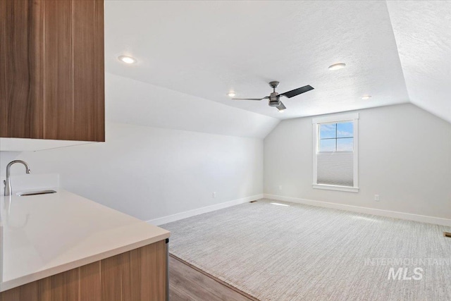13958 Levendi Ct, Caldwell, ID 83607 - bar area featuring a sink, baseboards, lofted ceiling, a ceiling fan, and light wood finished floors