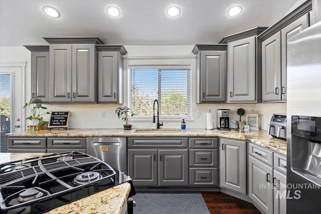 kitchen with stainless steel appliances, gray cabinets, and a sink