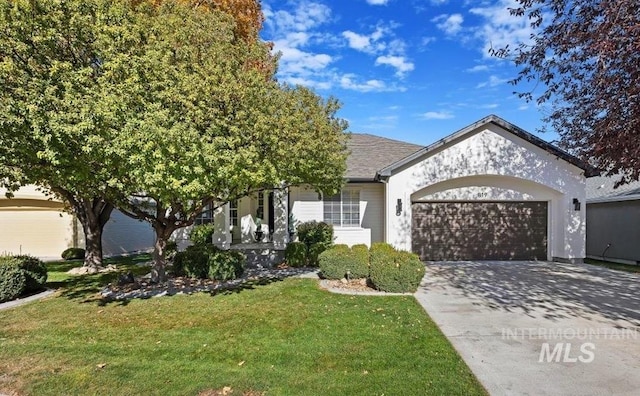 view of front of house with a garage, stucco siding, concrete driveway, and a front yard