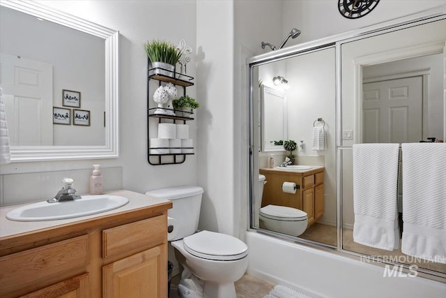 full bathroom featuring toilet, tile patterned floors, enclosed tub / shower combo, and vanity