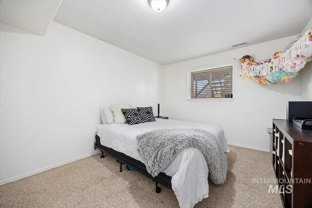 carpeted bedroom featuring visible vents and baseboards