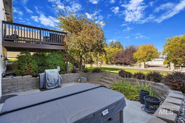 view of patio / terrace featuring a grill, a wooden deck, and a hot tub