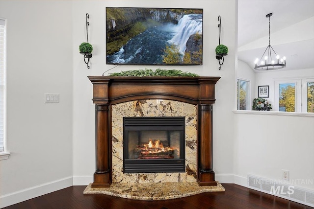 room details with a high end fireplace, baseboards, and wood finished floors