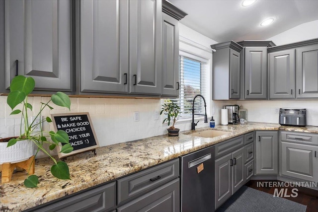 kitchen featuring a sink, gray cabinets, backsplash, light stone countertops, and dishwasher