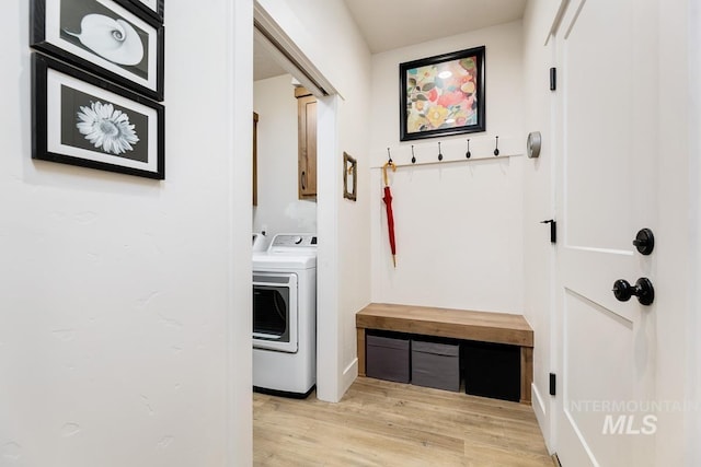 washroom featuring cabinets, washer / clothes dryer, and light hardwood / wood-style flooring