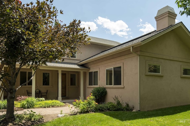 205 Shaun Ln, Hailey, ID 83333 - rear view of house featuring stucco siding, a yard, and roof with shingles