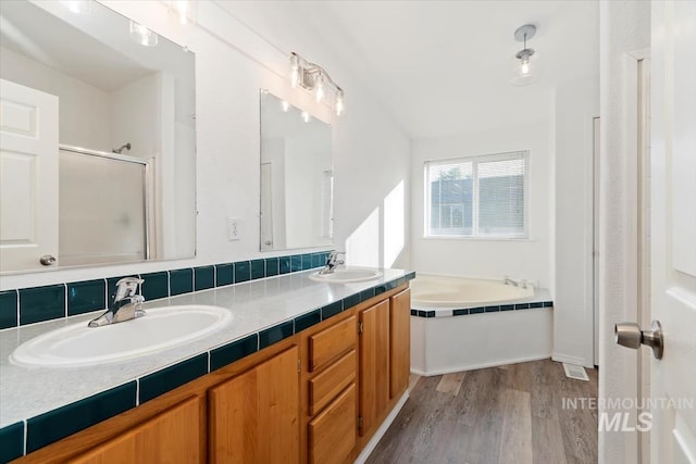 1404 River Run Ln, Caldwell, ID 83605 - bathroom featuring a garden tub, double vanity, wood finished floors, and a shower with door