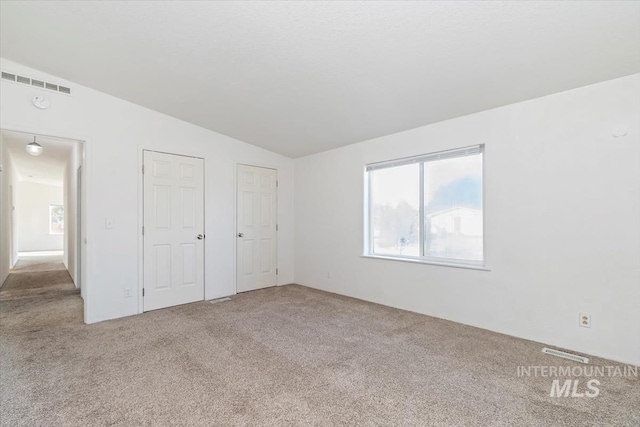 1404 River Run Ln, Caldwell, ID 83605 - unfurnished bedroom with carpet floors, lofted ceiling, and two closets