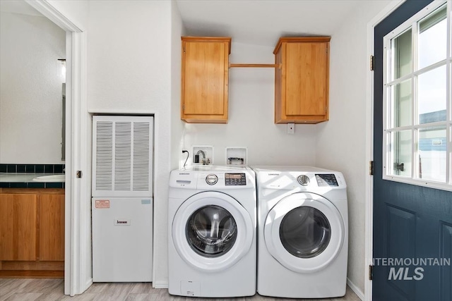1404 River Run Ln, Caldwell, ID 83605 - washroom with a heating unit, cabinet space, washing machine and clothes dryer, and light wood-style flooring