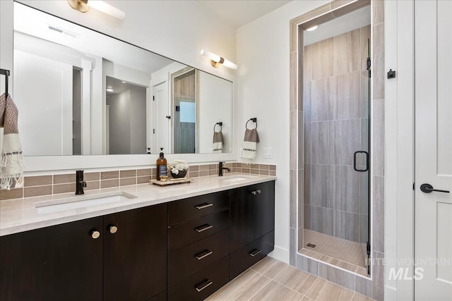 bathroom with vanity, an enclosed shower, and decorative backsplash