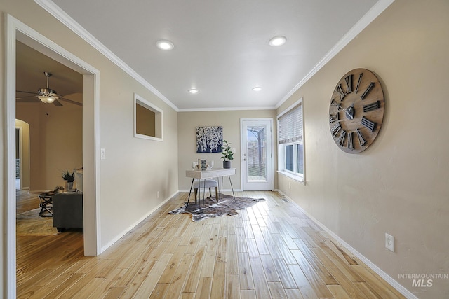 hall with light wood-type flooring, recessed lighting, baseboards, crown molding, and arched walkways