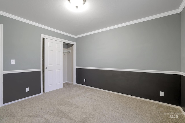 unfurnished bedroom featuring ornamental molding, carpet, a closet, and baseboards