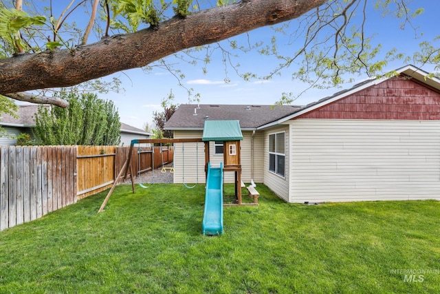 back of house with a playground and roof with shingles