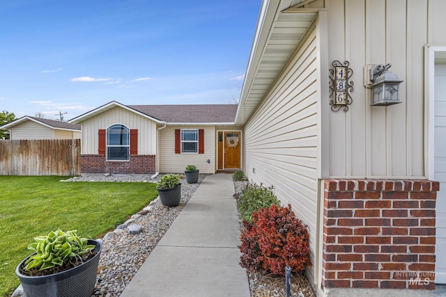 property entrance with board and batten siding, brick siding, and roof with shingles