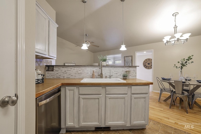 kitchen featuring dishwasher, a sink, tasteful backsplash, a peninsula, and a chandelier