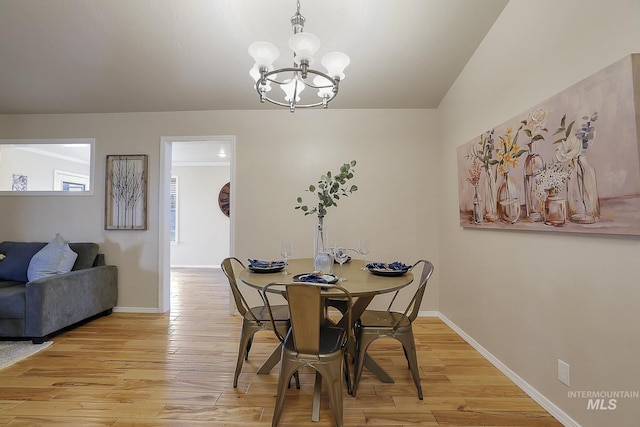 dining room featuring light wood-style flooring, a chandelier, and baseboards