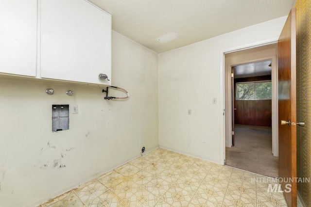 clothes washing area featuring cabinet space, baseboards, tile patterned floors, and hookup for a gas dryer