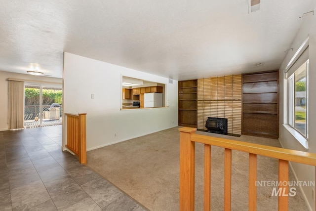 unfurnished living room with baseboards and built in shelves