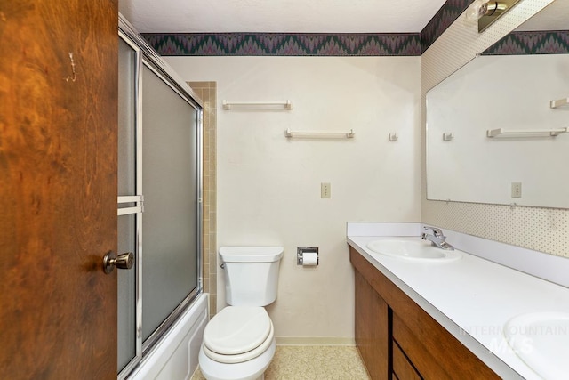 full bathroom featuring toilet, double vanity, baseboards, shower / bath combination with glass door, and tile patterned flooring