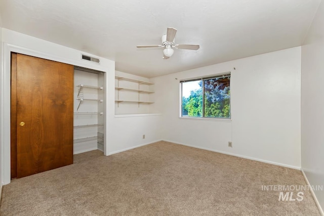 carpeted spare room with baseboards and ceiling fan