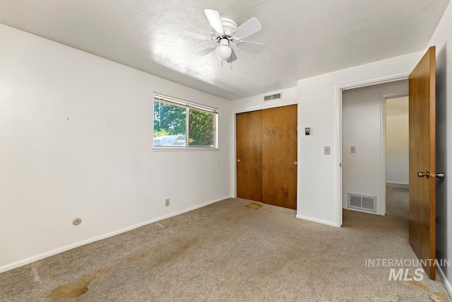unfurnished bedroom featuring carpet, a closet, baseboards, and a ceiling fan